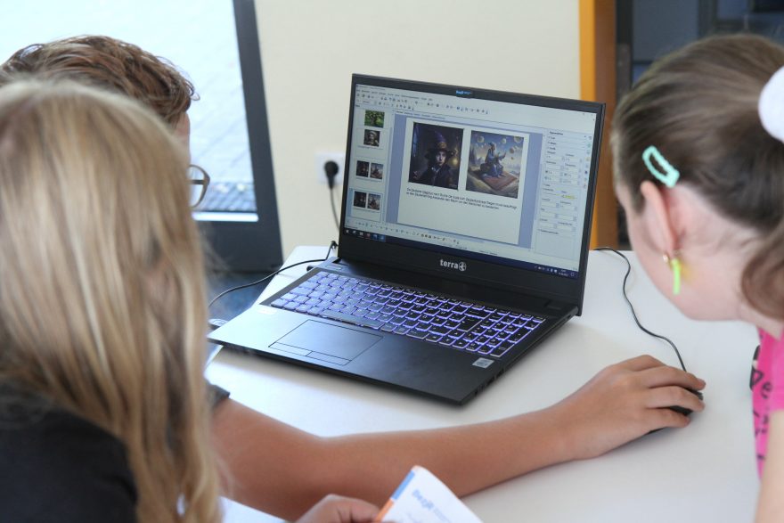 Teilnehmende beim Erstellen einer Fotogeschichte am Computer.